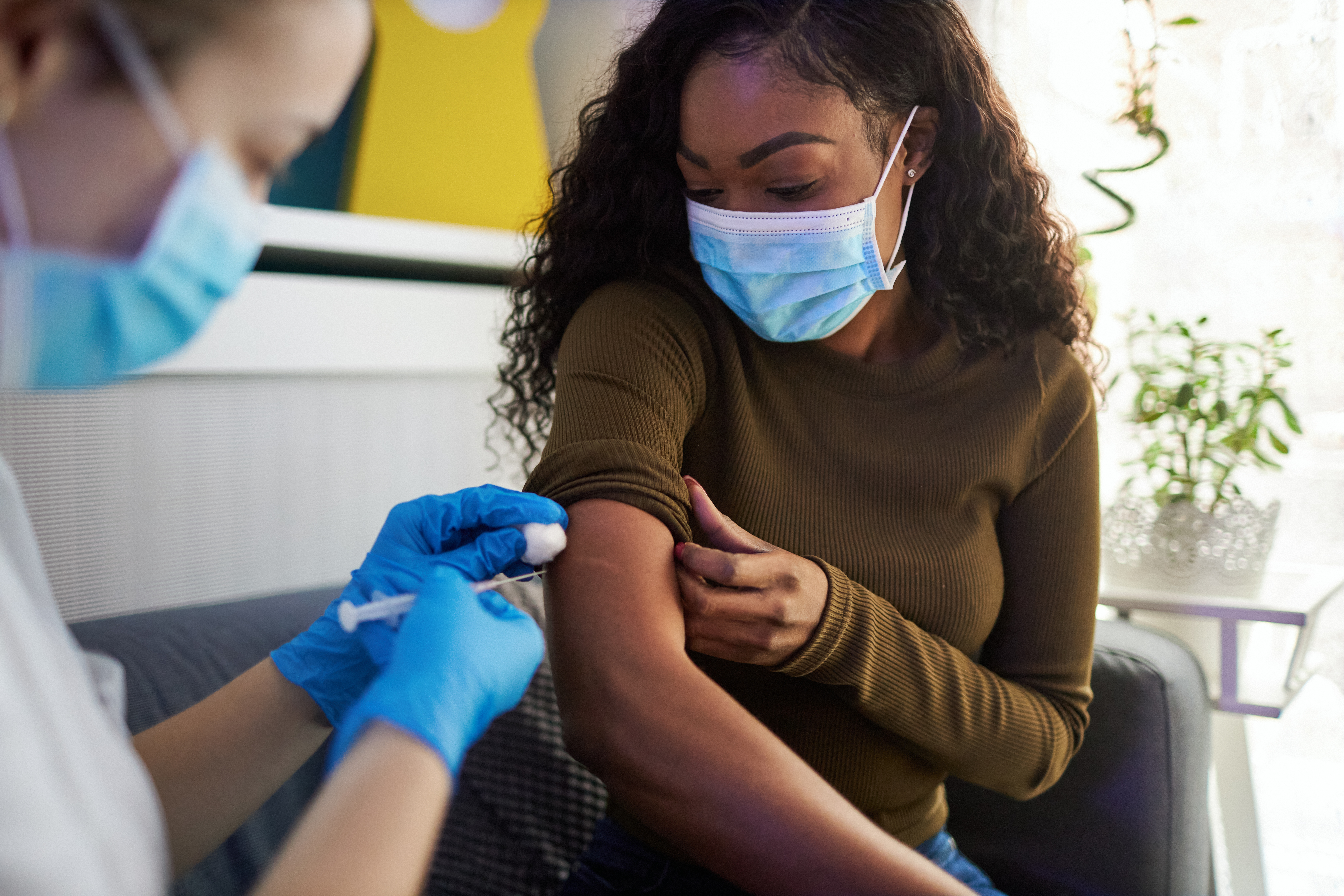 Image of woman getting a vaccine; Image Credit: iStock